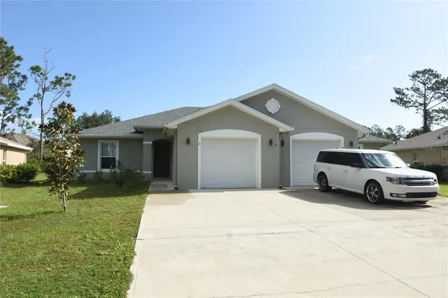 a front view of a house with a garden and yard