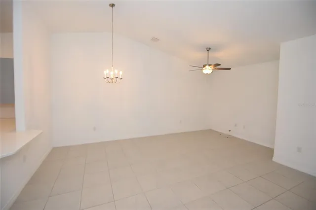 a view of a room with a hanging light and kitchen
