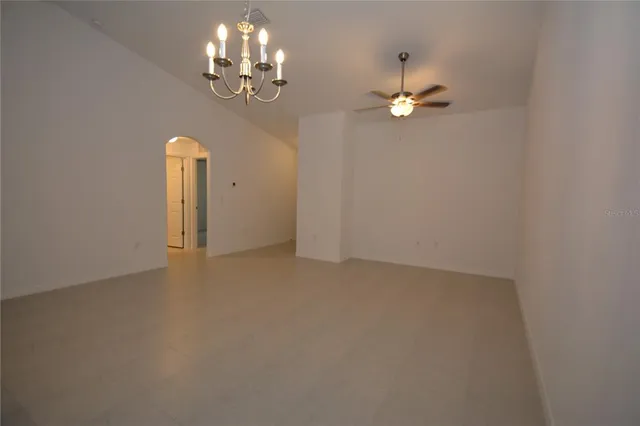 en empty room with windows and ceiling fan
