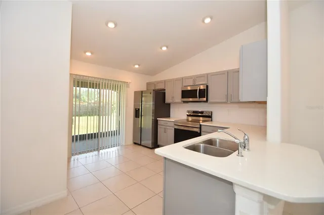 a kitchen with a sink a microwave and refrigerator