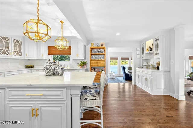 a living room with furniture a flat screen tv and a chandelier