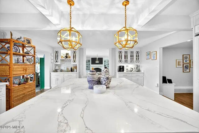 a kitchen with stainless steel appliances kitchen island granite countertop a table chairs sink and cabinets