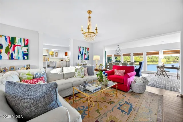 a dining room with furniture a chandelier and wooden floor