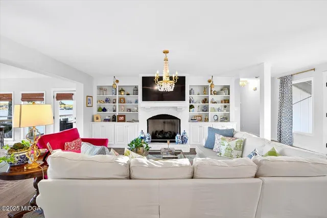 a dining room with furniture a chandelier and wooden floor