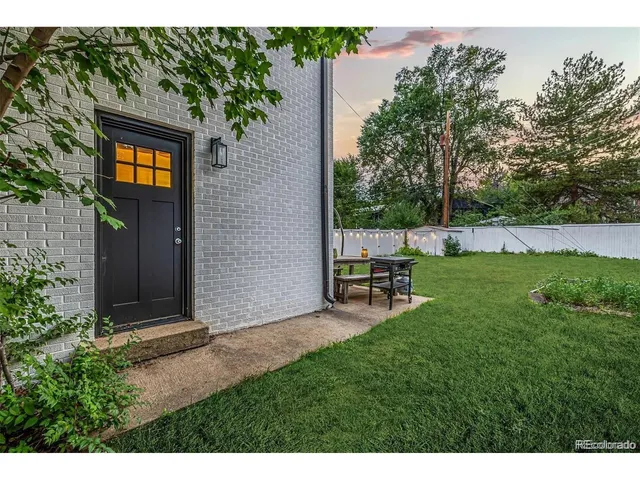 a backyard of a house with table and chairs