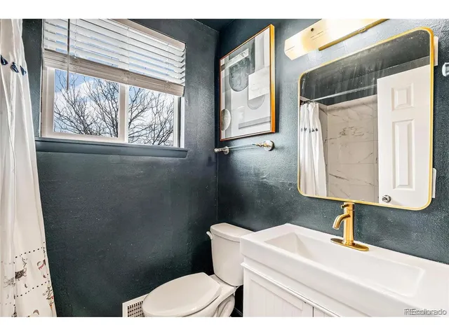 a bathroom with a toilet a sink and a mirror