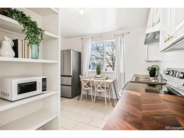 a kitchen with stainless steel appliances kitchen island granite countertop a table and chairs in it