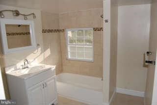 2904 Allendale Road Baltimore, MD 21216 - Photo 22 of 30 a bathroom with a bathtub a sink and a mirror
