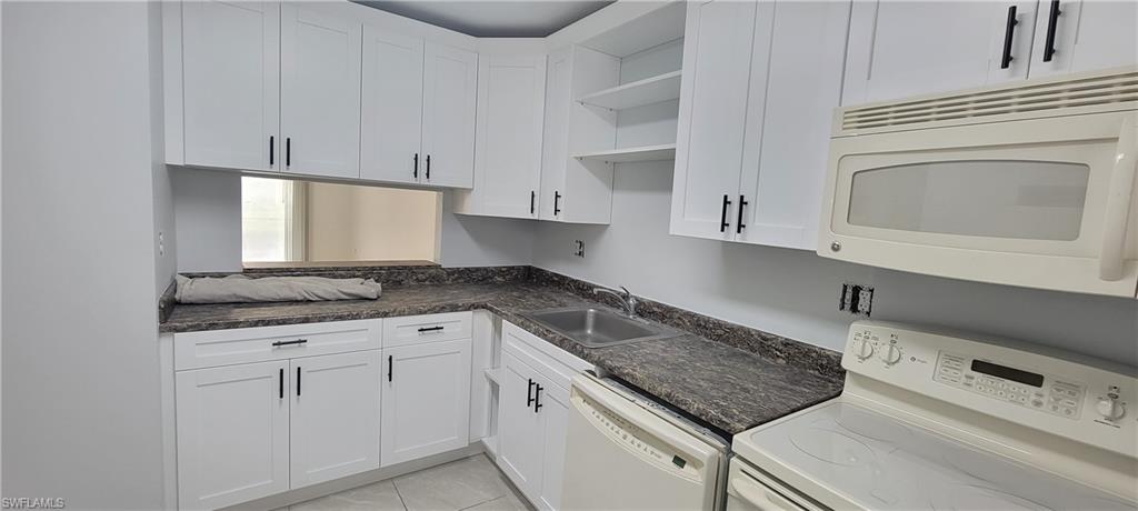 5233 Treetops Drive, Unit Y102 Naples, FL 34113 - Photo 2 of 9 a kitchen with granite countertop a sink a stove and cabinets