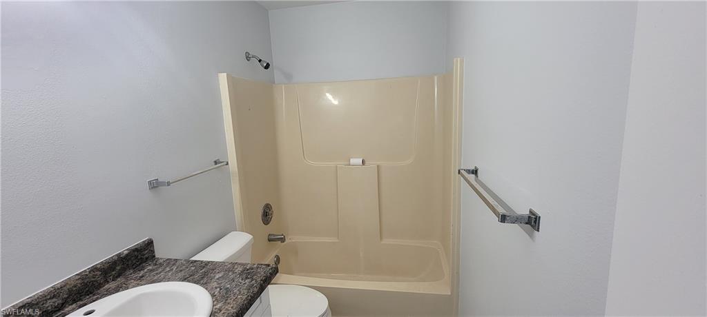 5233 Treetops Drive, Unit Y102 Naples, FL 34113 - Photo 9 of 9 a bathroom with a granite countertop bathtub shower sink vanity and toilet