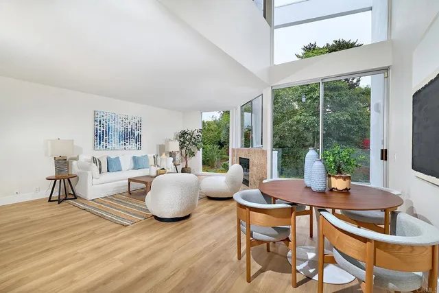 a living room with fireplace furniture and a large window