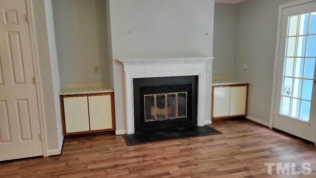 4362 Bona Court Raleigh, NC 27604 - Photo 4 of 17 an empty room with wooden floor fireplace and windows