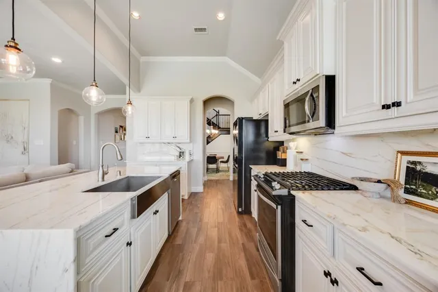 a kitchen with granite countertop a sink stove and cabinets