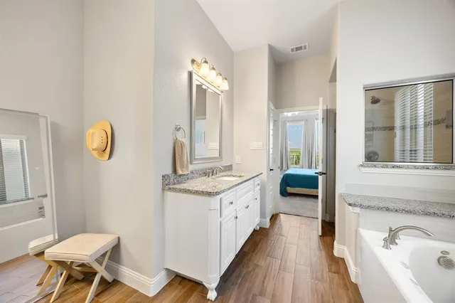 a spacious bathroom with a granite countertop sink and a mirror