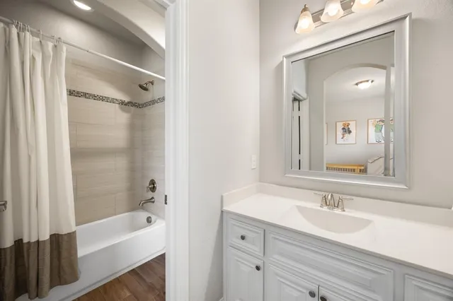 a bathroom with a tub sink and mirror