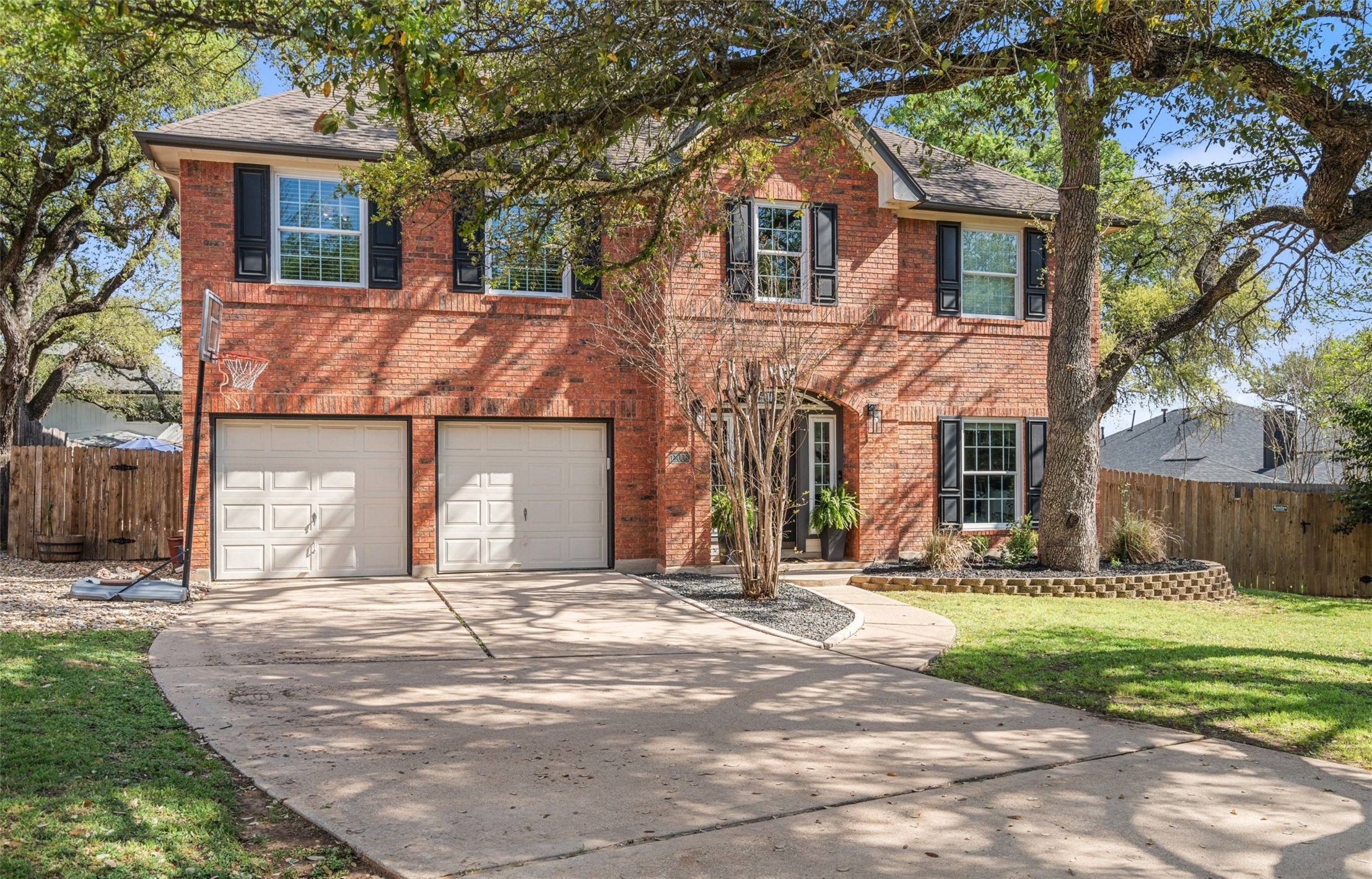 11006 Needham Court Austin, TX 78739 - Photo 1 of 1 Colonial home featuring an attached garage, fence, brick siding, and concrete driveway