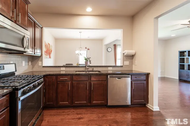 a kitchen with stainless steel appliances a sink and stove top oven