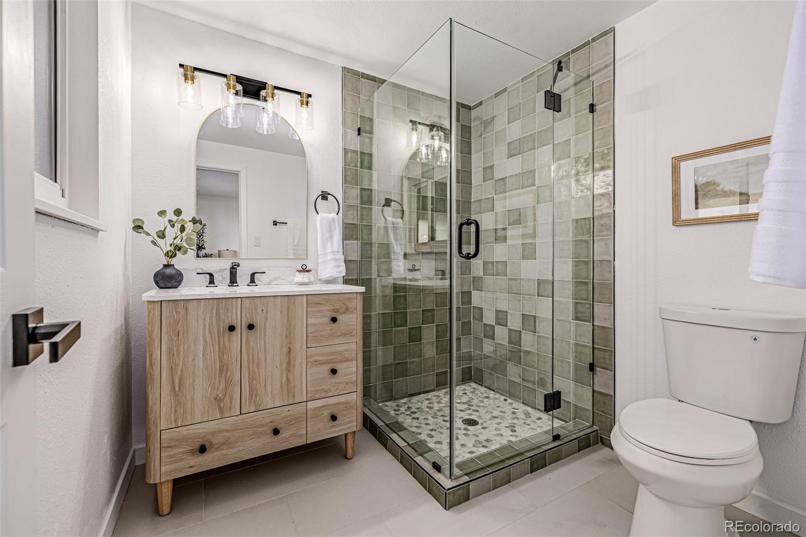 3831 West Rutgers Place Denver, CO 80236 - Photo 15 of 35 a bathroom with a shower sink mirror and toilet
