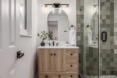 a bathroom with a sink vanity granite tub shower and mirror