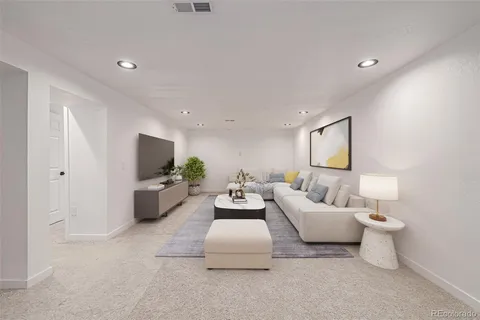 a living room with furniture a flat screen tv and a lamp