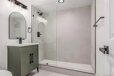 a bathroom with a shower a sink and mirror