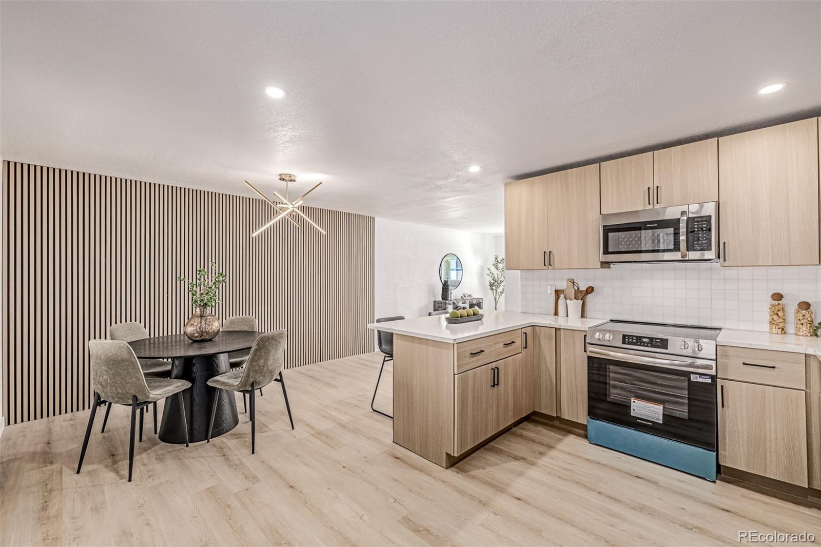 3831 West Rutgers Place Denver, CO 80236 - Photo 9 of 35 a kitchen with a table chairs stove and cabinets
