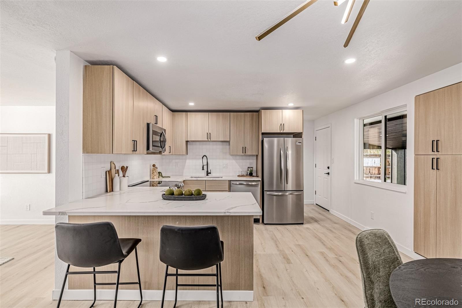 3831 West Rutgers Place Denver, CO 80236 - Photo 10 of 35 a kitchen with refrigerator and cabinets