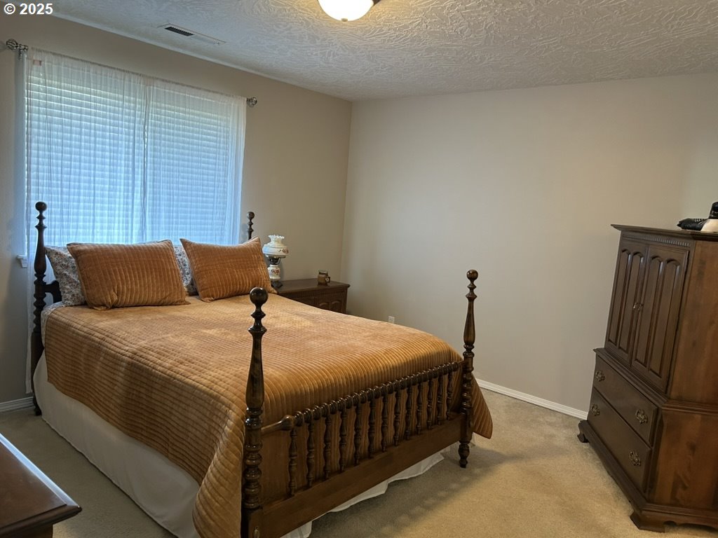736 Kelsey Loop Molalla, OR 97038 - Photo 11 of 21 a bedroom with a bed and wooden floor