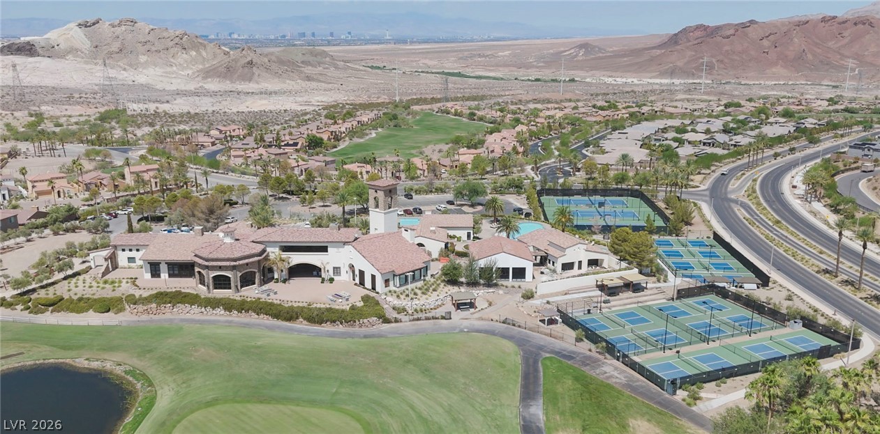 3 Rue Promenade Way Henderson, NV 89011 - Photo 12 of 26 An aerial perspective showcases a vibrant community with recreational amenities set against a rugged mountain backdrop.