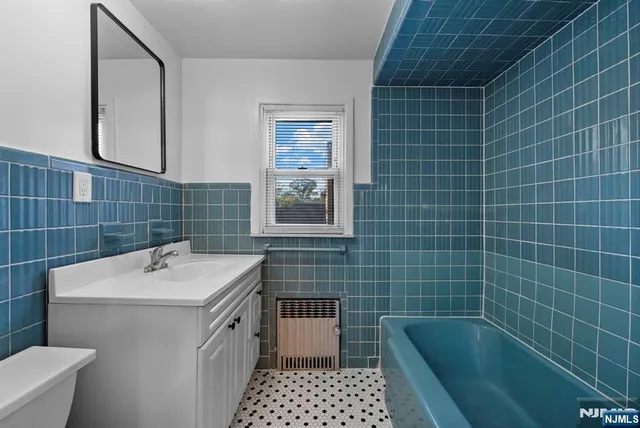 a bathroom with a sink a toilet a mirror and shower