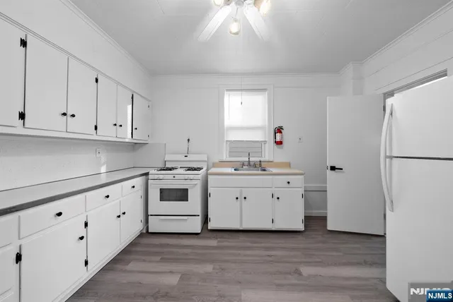 a kitchen with white cabinets and white appliances