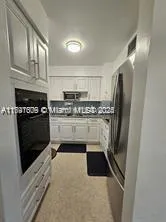 a kitchen with stainless steel appliances granite countertop a refrigerator a stove a sink and a microwave