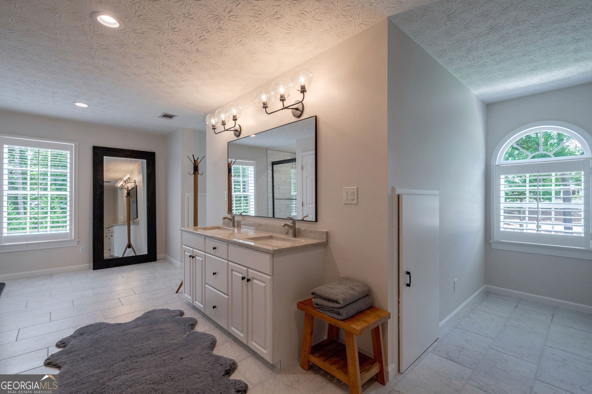 2391 Rabbit Farm Circle Loganville, GA 30052 - Photo 56 of 97 a spacious bathroom with a granite countertop sink a mirror and a shower