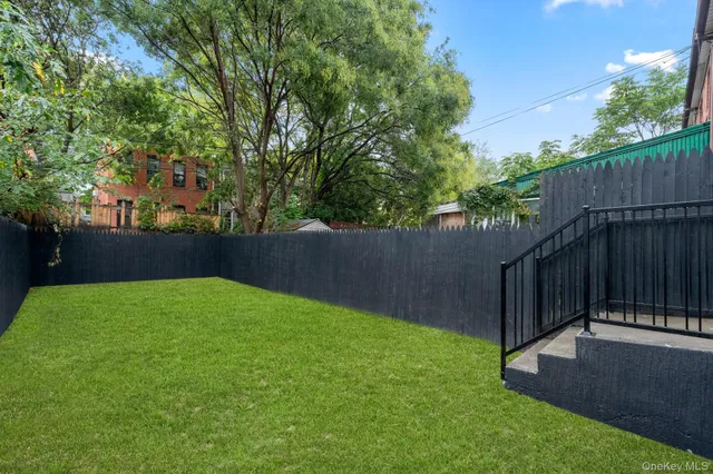 a view of a backyard with a small cabin and wooden fence