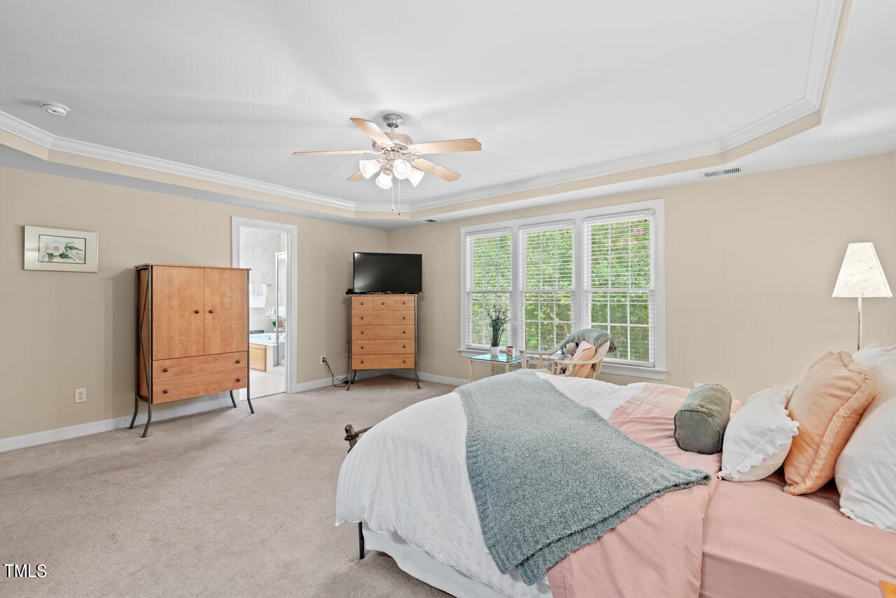 7930 Pine Timber Drive Raleigh, NC 27613 - Photo 32 of 57 a spacious bedroom with a bed and a chandelier