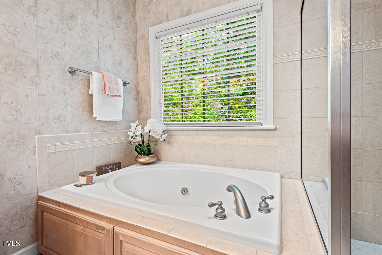7930 Pine Timber Drive Raleigh, NC 27613 - Photo 37 of 57 a bathroom with a bathtub and a window