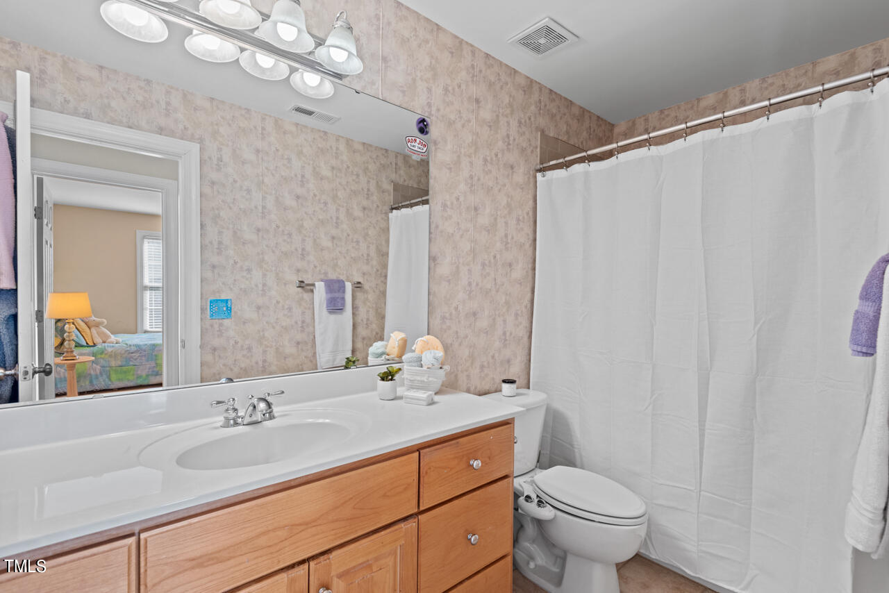 7930 Pine Timber Drive Raleigh, NC 27613 - Photo 44 of 57 a bathroom with a granite countertop sink a toilet and a mirror