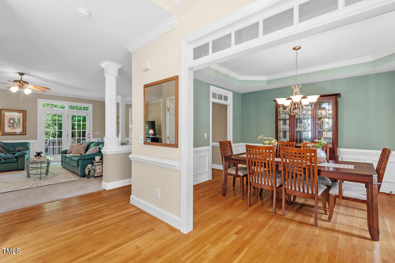 7930 Pine Timber Drive Raleigh, NC 27613 - Photo 7 of 57 a dining room with furniture a chandelier and wooden floor