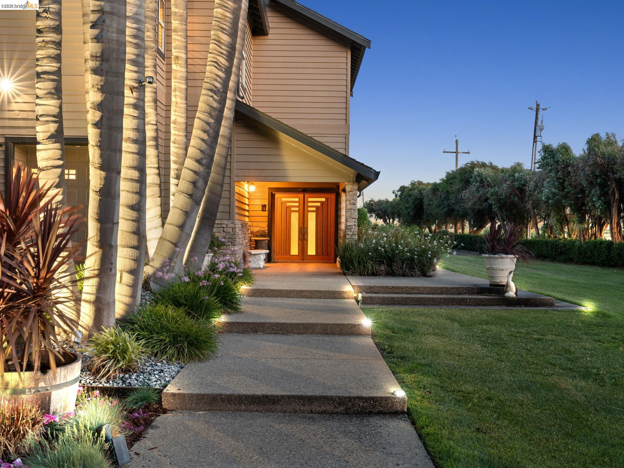 17035 Terminous Road Isleton, CA 95641 - Photo 16 of 48 View of exterior entry with a yard, french doors, and stone siding
