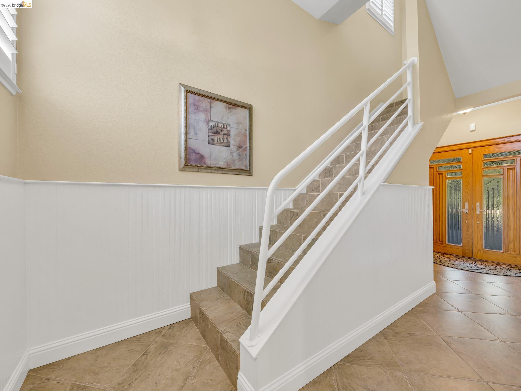 17035 Terminous Road Isleton, CA 95641 - Photo 18 of 48 Staircase featuring wainscoting, tile patterned flooring, and a high ceiling