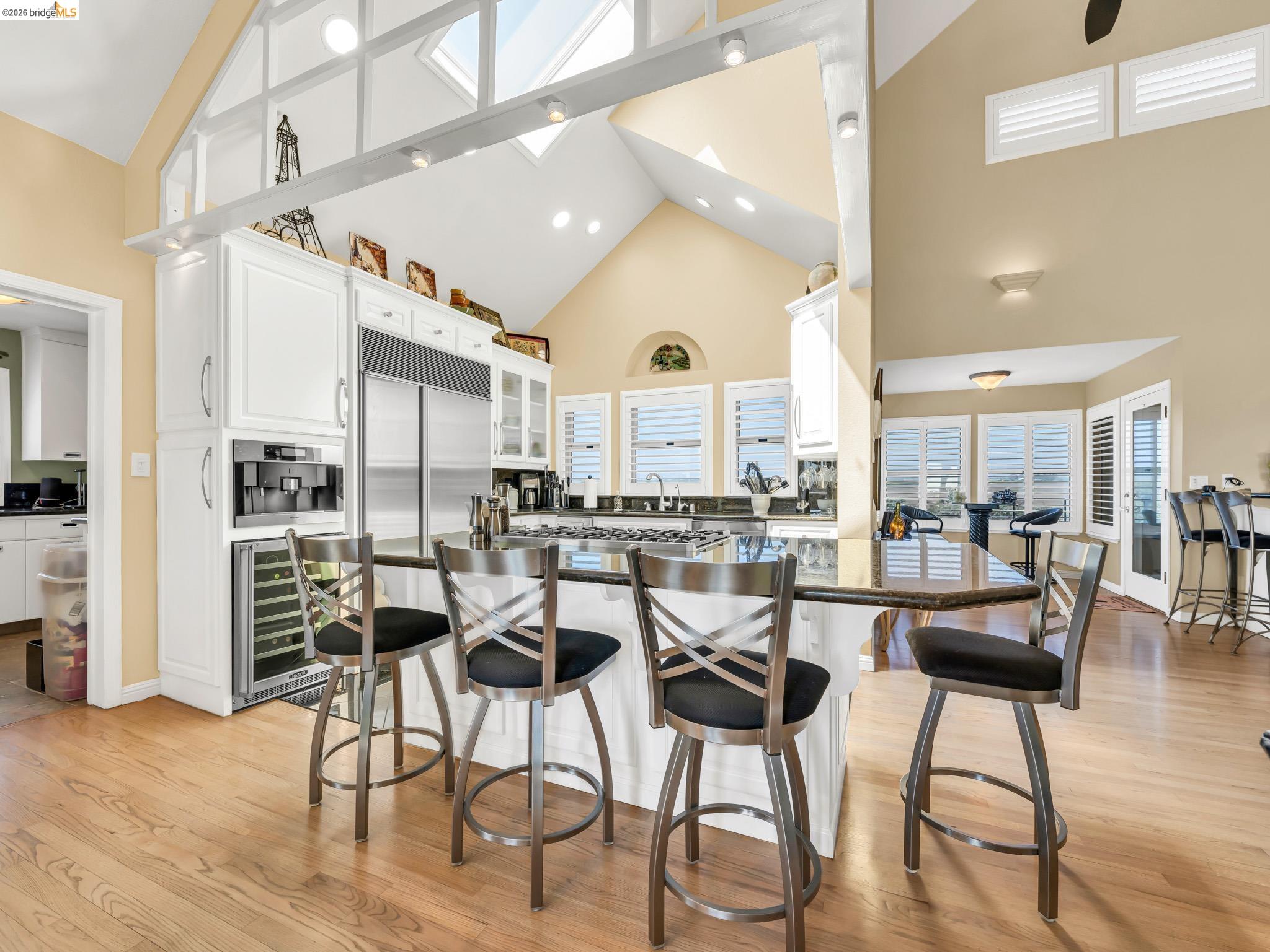 17035 Terminous Road Isleton, CA 95641 - Photo 20 of 48 Kitchen with a breakfast bar, white cabinets, wine cooler, lofted ceiling, and light wood-style floors