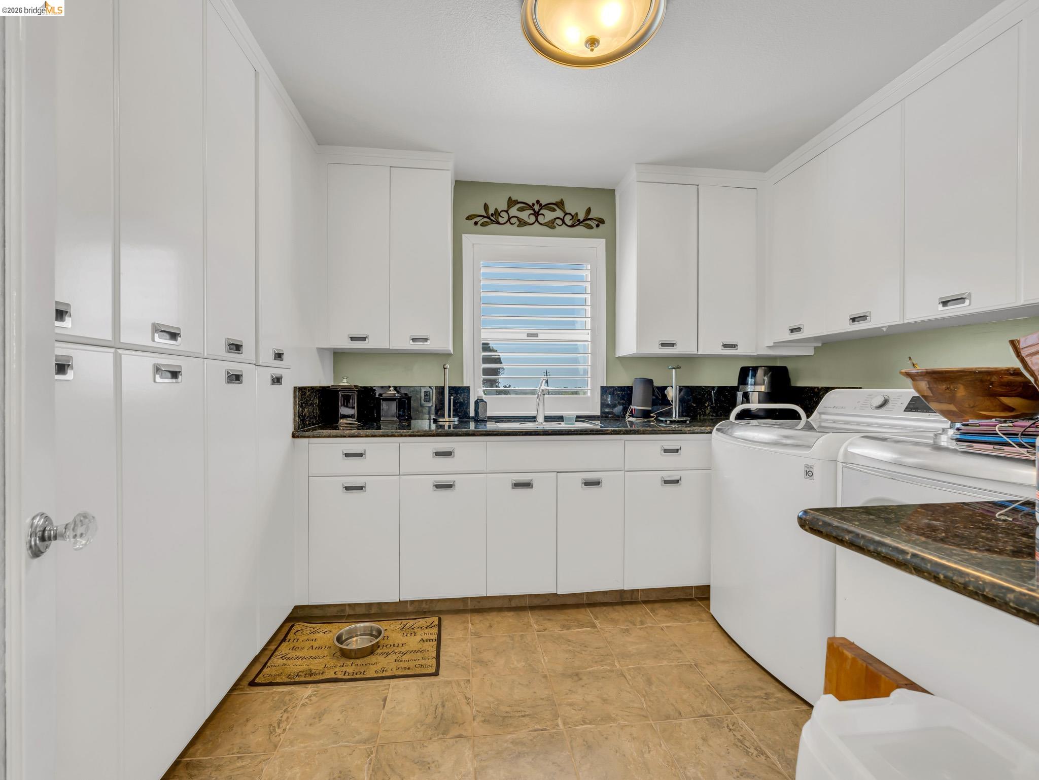 17035 Terminous Road Isleton, CA 95641 - Photo 21 of 48 Laundry area featuring washing machine and clothes dryer and cabinet space