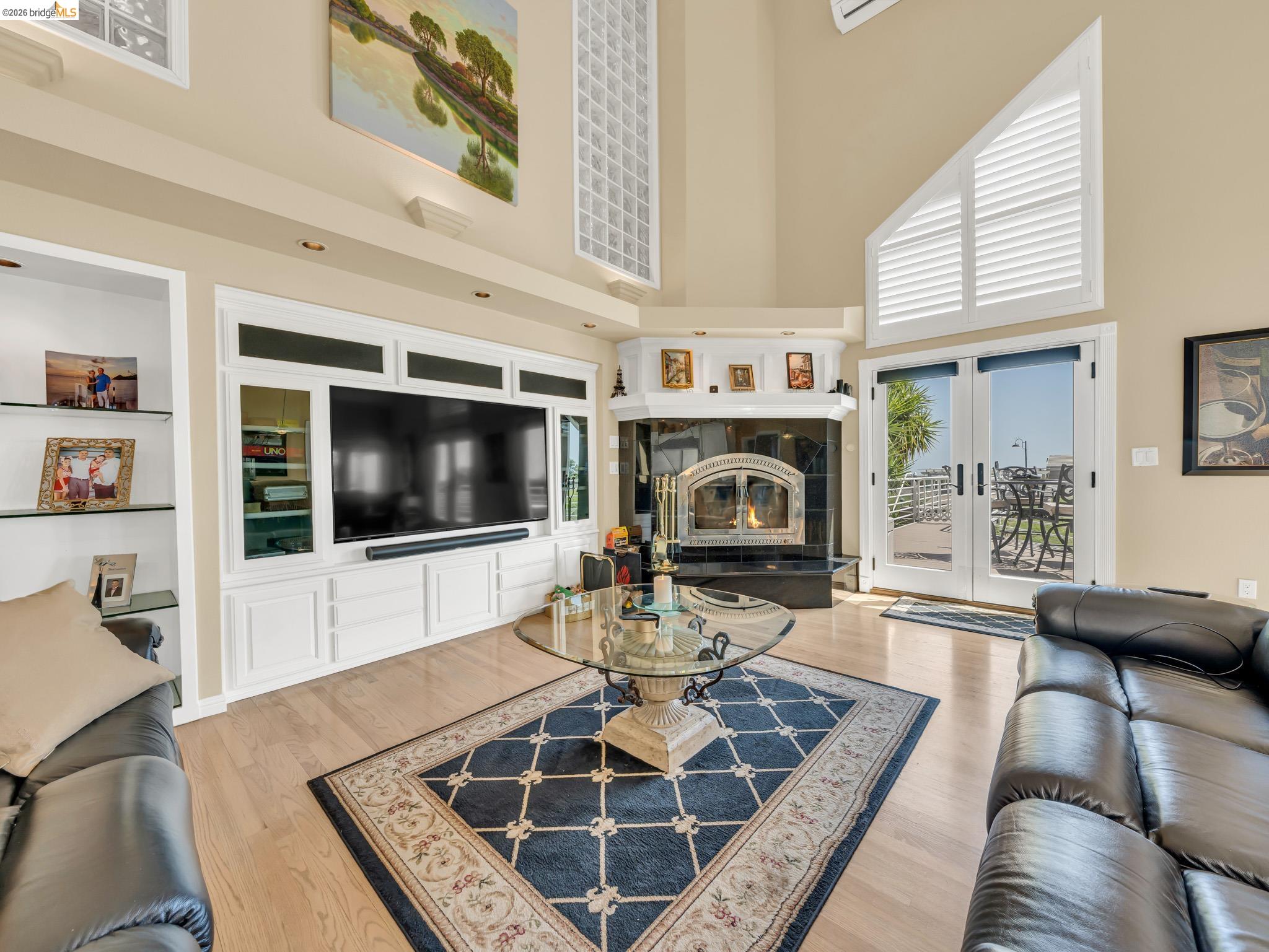 17035 Terminous Road Isleton, CA 95641 - Photo 23 of 48 Living room with wood finished floors, a high ceiling, a fireplace, and built in features