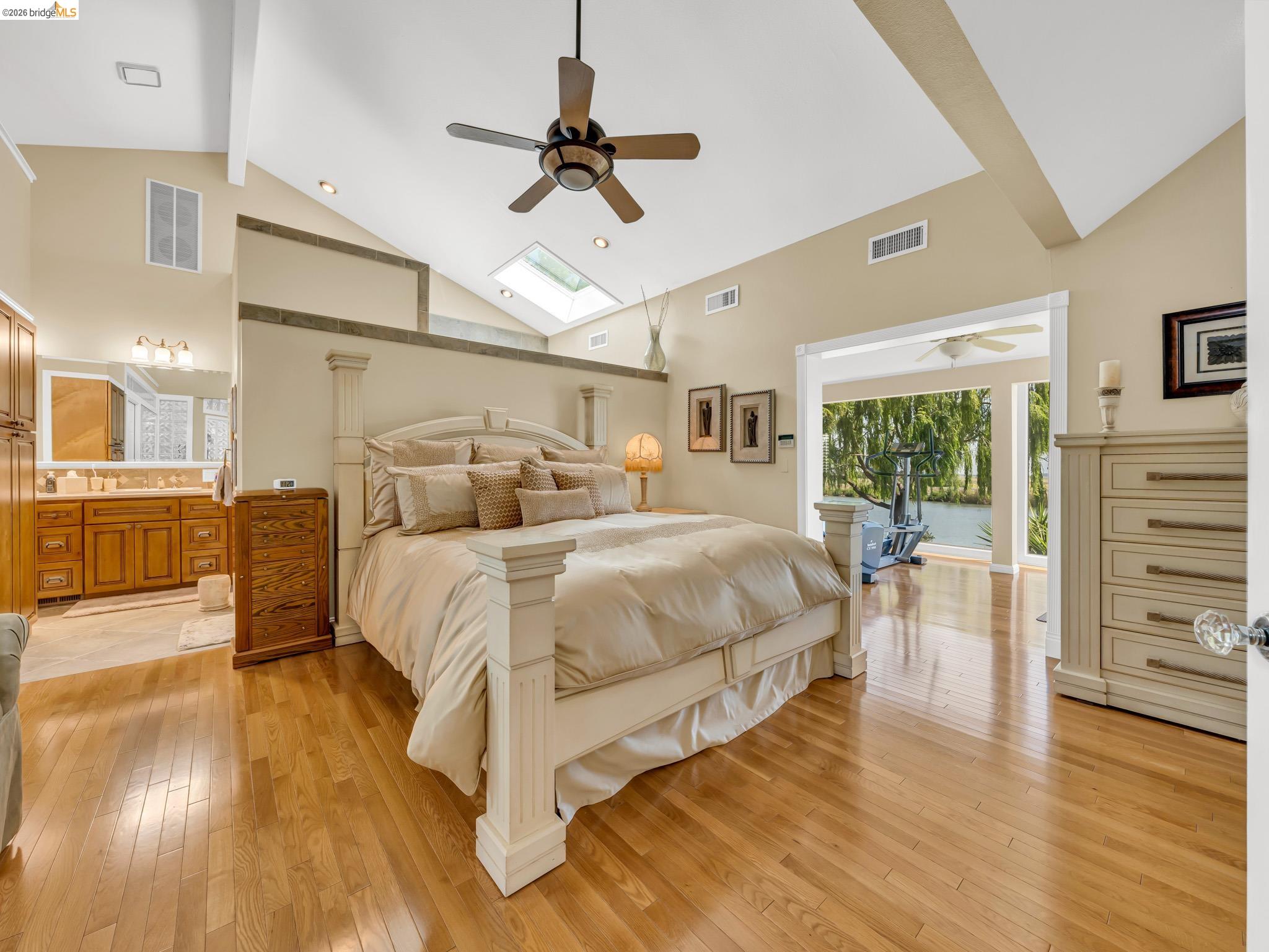 17035 Terminous Road Isleton, CA 95641 - Photo 27 of 48 Bedroom featuring a skylight, light wood finished floors, lofted ceiling, a ceiling fan, and ensuite bathroom