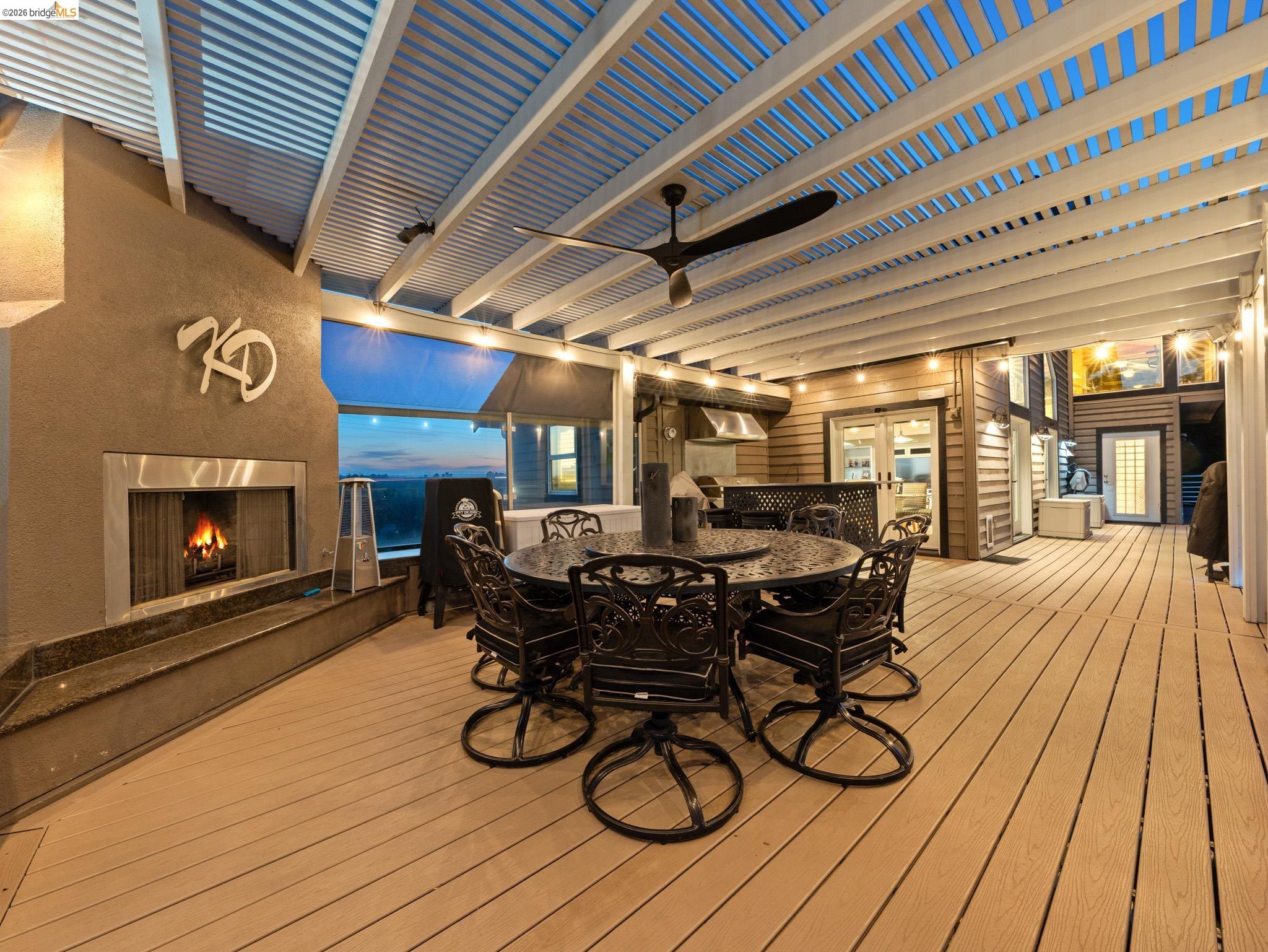 17035 Terminous Road Isleton, CA 95641 - Photo 43 of 48 Wooden deck with outdoor dining space, a high end fireplace, and a ceiling fan