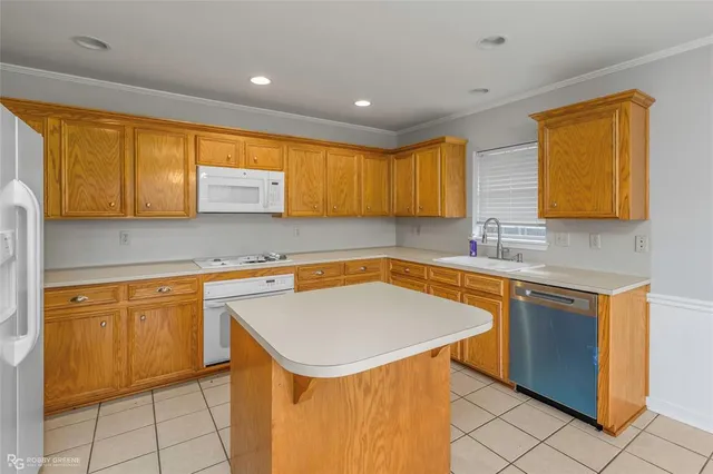 a kitchen with stainless steel appliances granite countertop a sink a stove a refrigerator a counter top space and cabinets