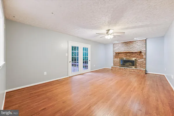 a view of an empty room with a window and a kitchen