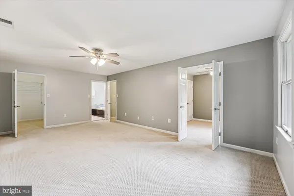 an empty room with a ceiling fan and a window