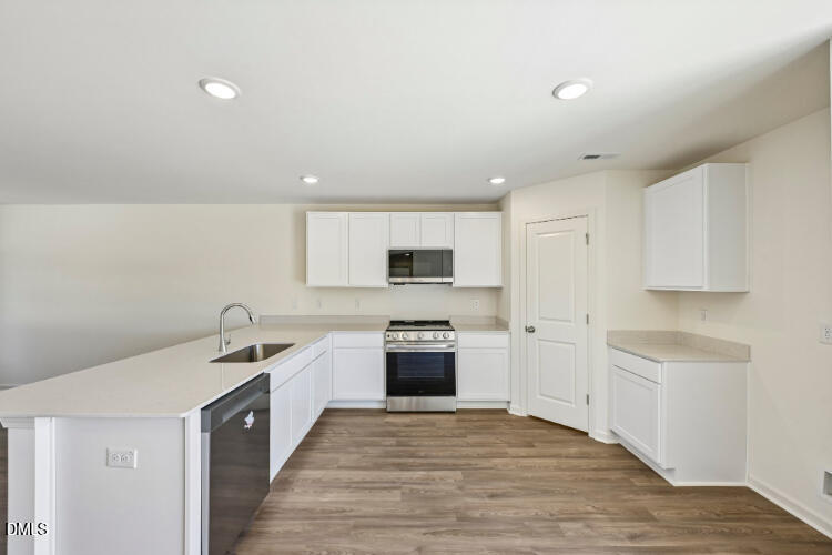 10955 Lancaster Store Road Castalia, NC 27816 - Photo 13 of 20 a kitchen with white cabinets and stainless steel appliances