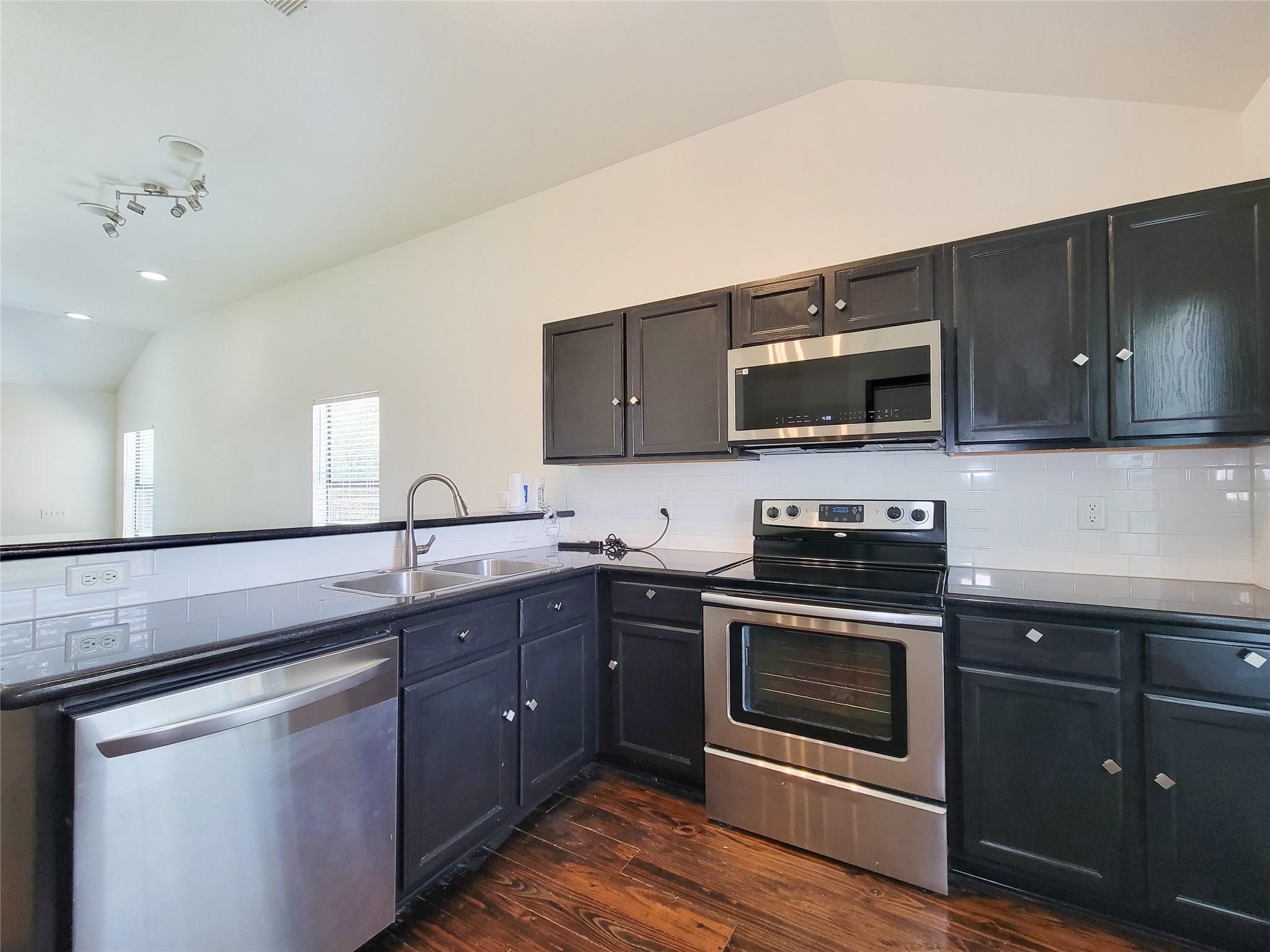 1904 Davis Street Houston, TX 77026 - Photo 12 of 33 a kitchen with stainless steel appliances granite countertop a sink a stove top oven and wooden cabinets